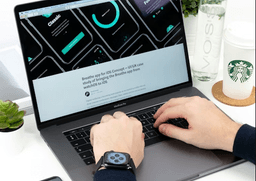 Person typing on MacBook with UI design